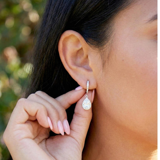 Close-up of a person wearing a diamond earring outdoors