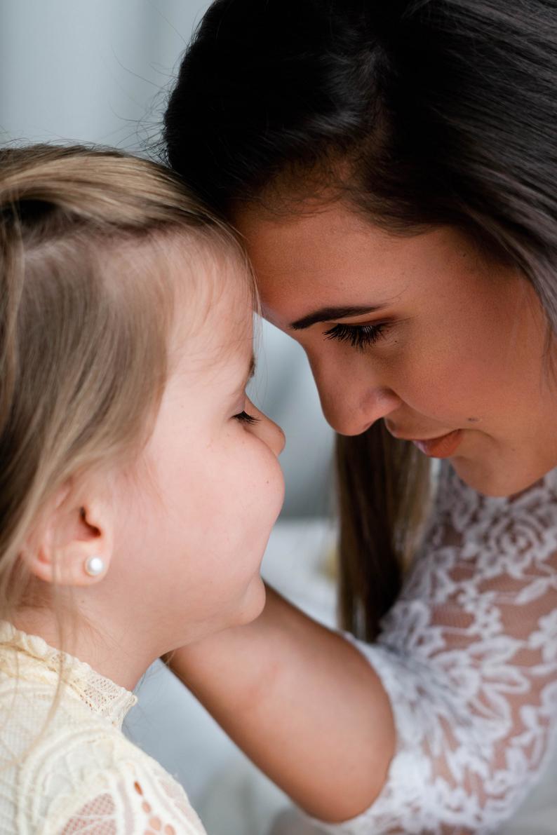 bride hugging flower girl with pearl stud earrings on