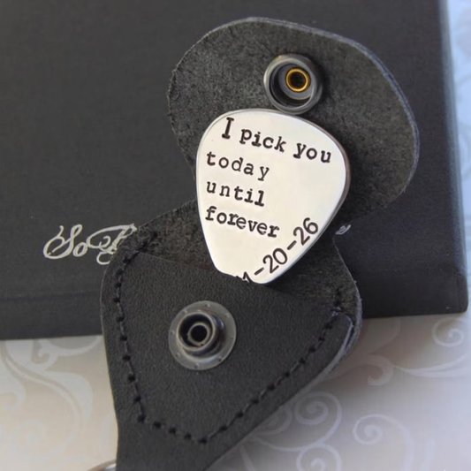 Personalized guitar pick with 'I pick you today until forever' text in a black case on a patterned background