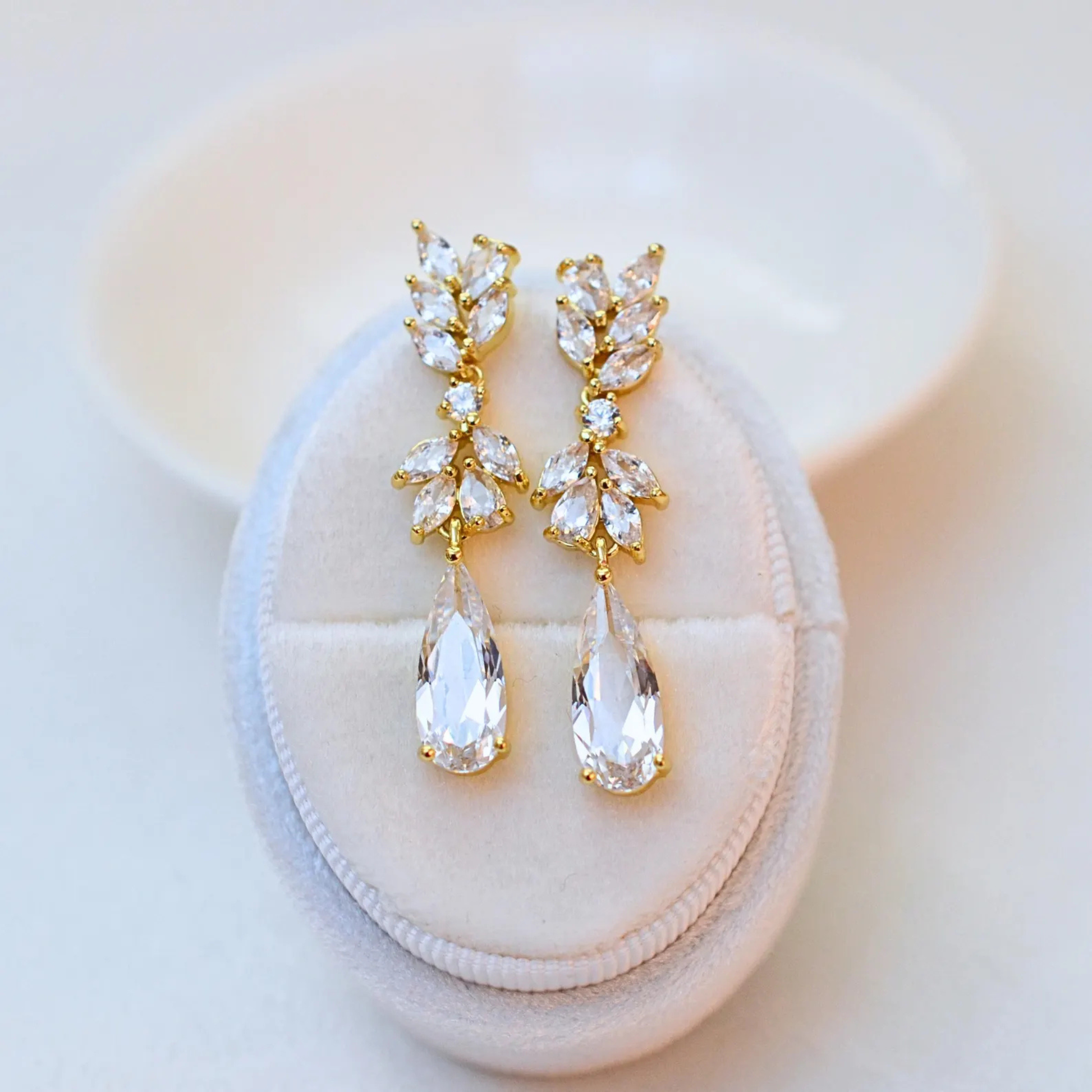 Gold cubic zirconia bridal teardrop earrings with a leaf cluster design.