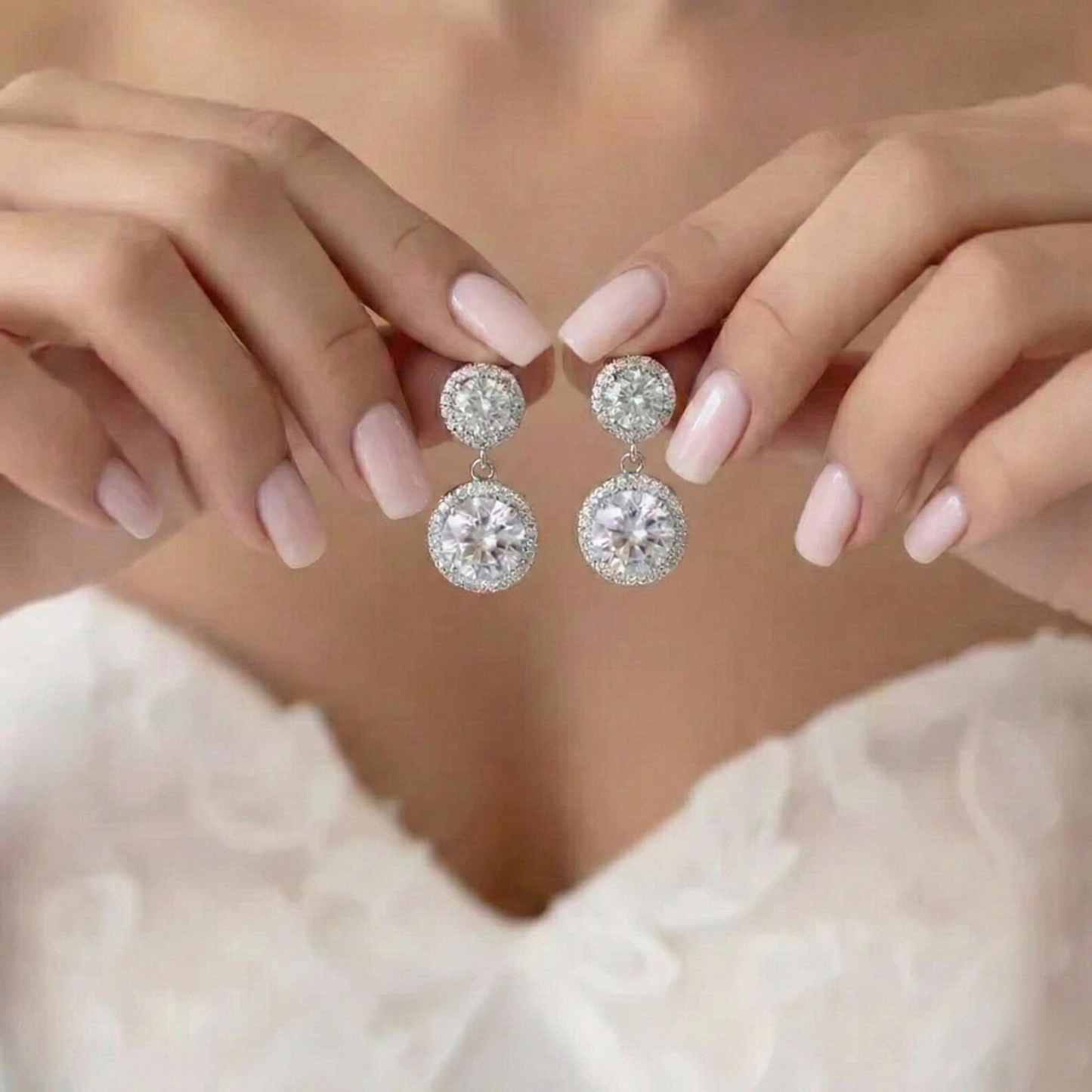 Close-up of a person wearing sparkling silver earrings with a soft focus background