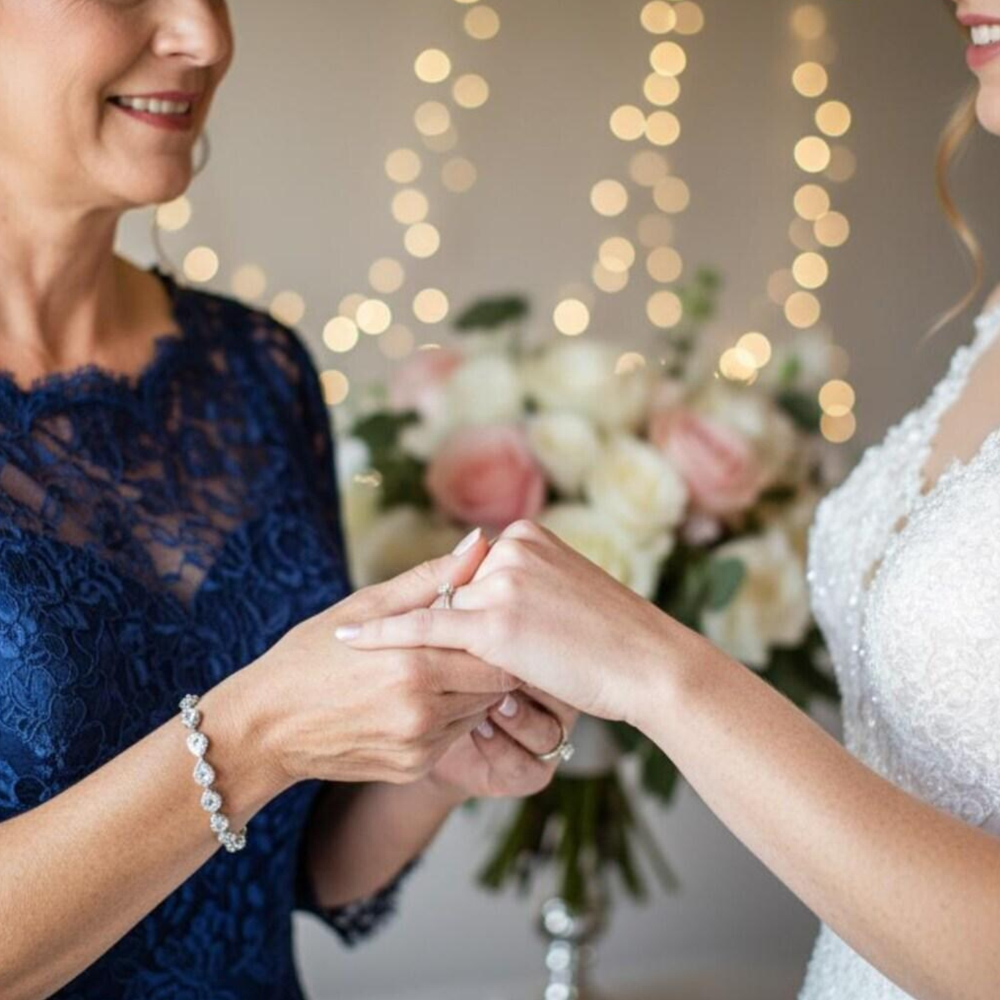 Bride and mother holding hands with the mother of the bride wearing a gorgeous Cubic Zirconia teardrop bracelet.