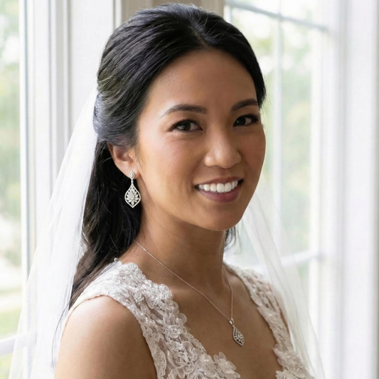 Woman wearing a wedding dress with a pair of art deco dangle earrings and wedding veil indoors