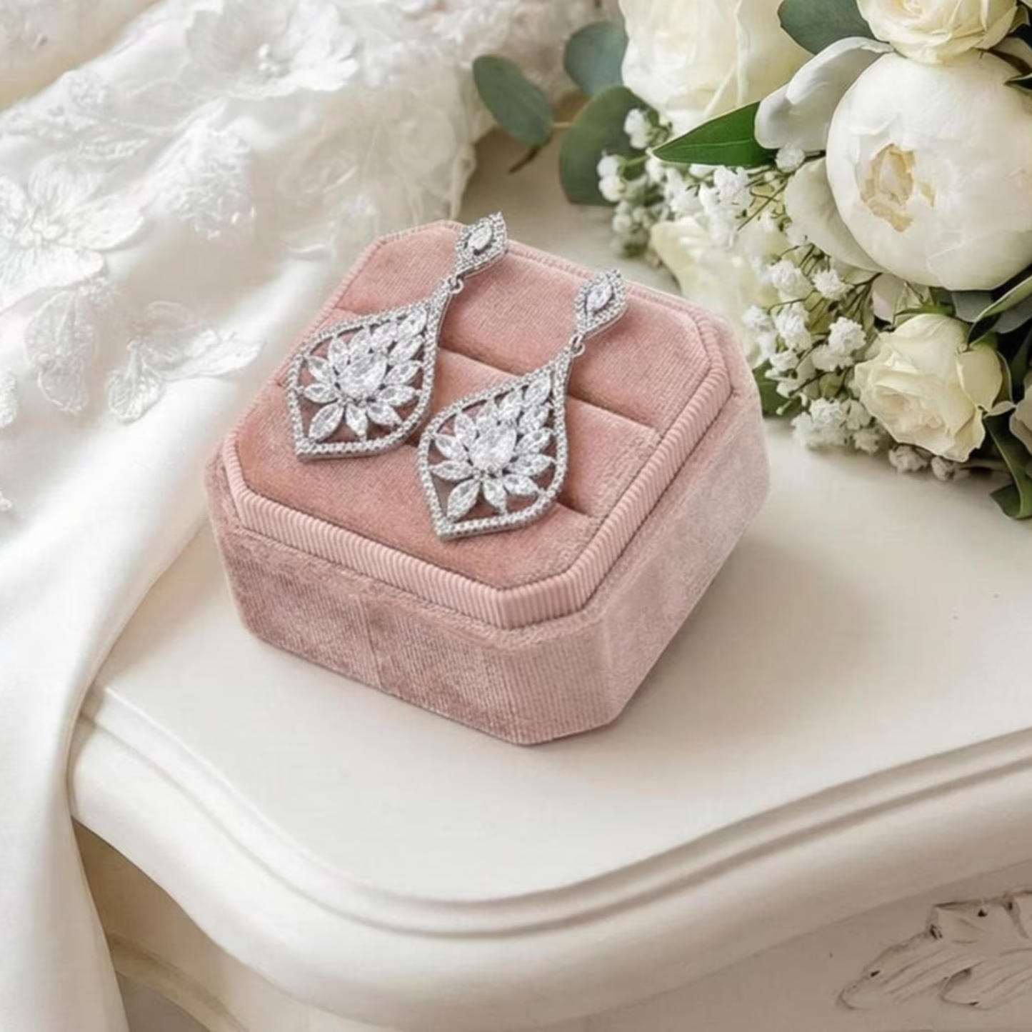 Faux CZ Diamond earrings on a pink velvet jewelry box with white flowers in the background