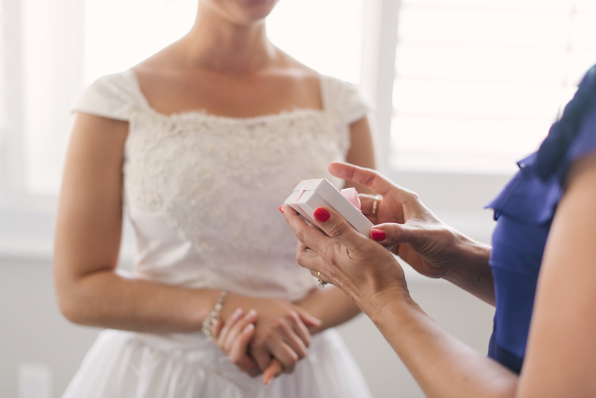 Bride giving Mom jewelry set on wedding day