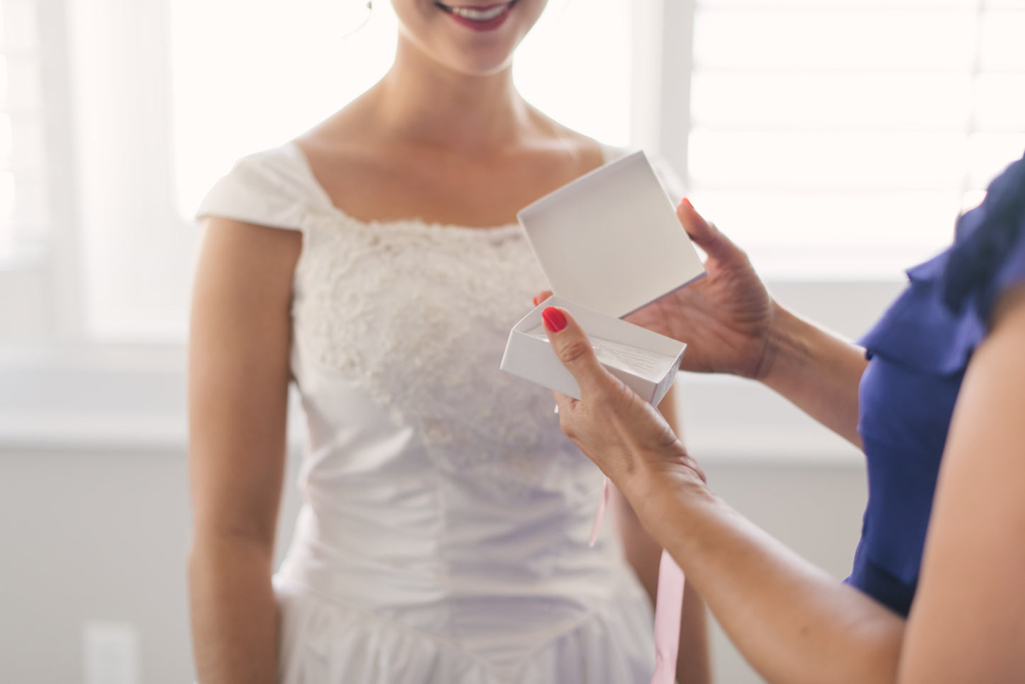 Mother of the bride opening jewelry gift set from Bride