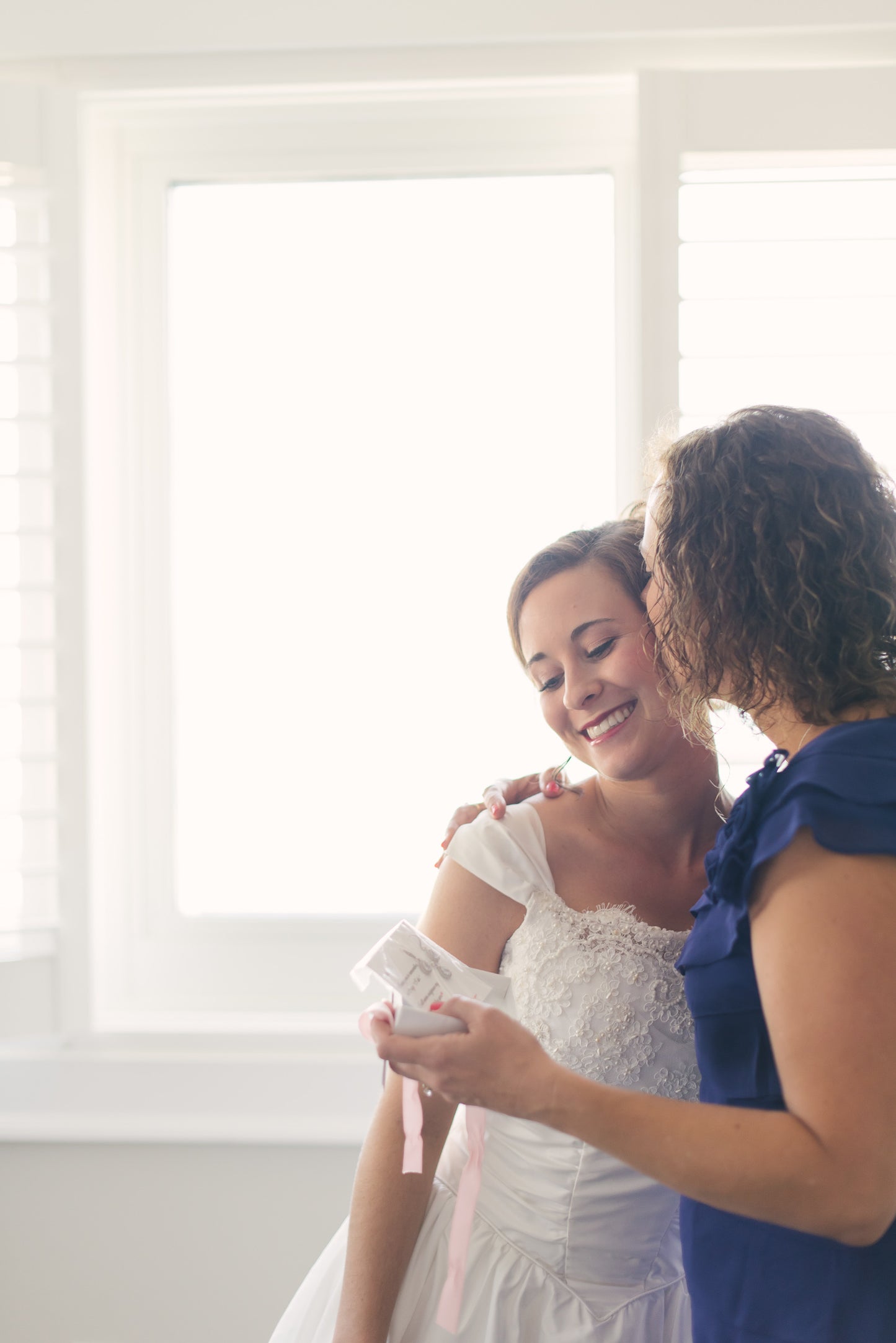 Mother of the bride hugging daughter on wedding day