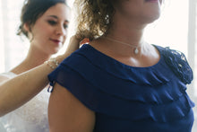 Bride placing necklace on mother of the brides neck