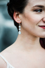 Beautiful bride wearing long crystal earrings