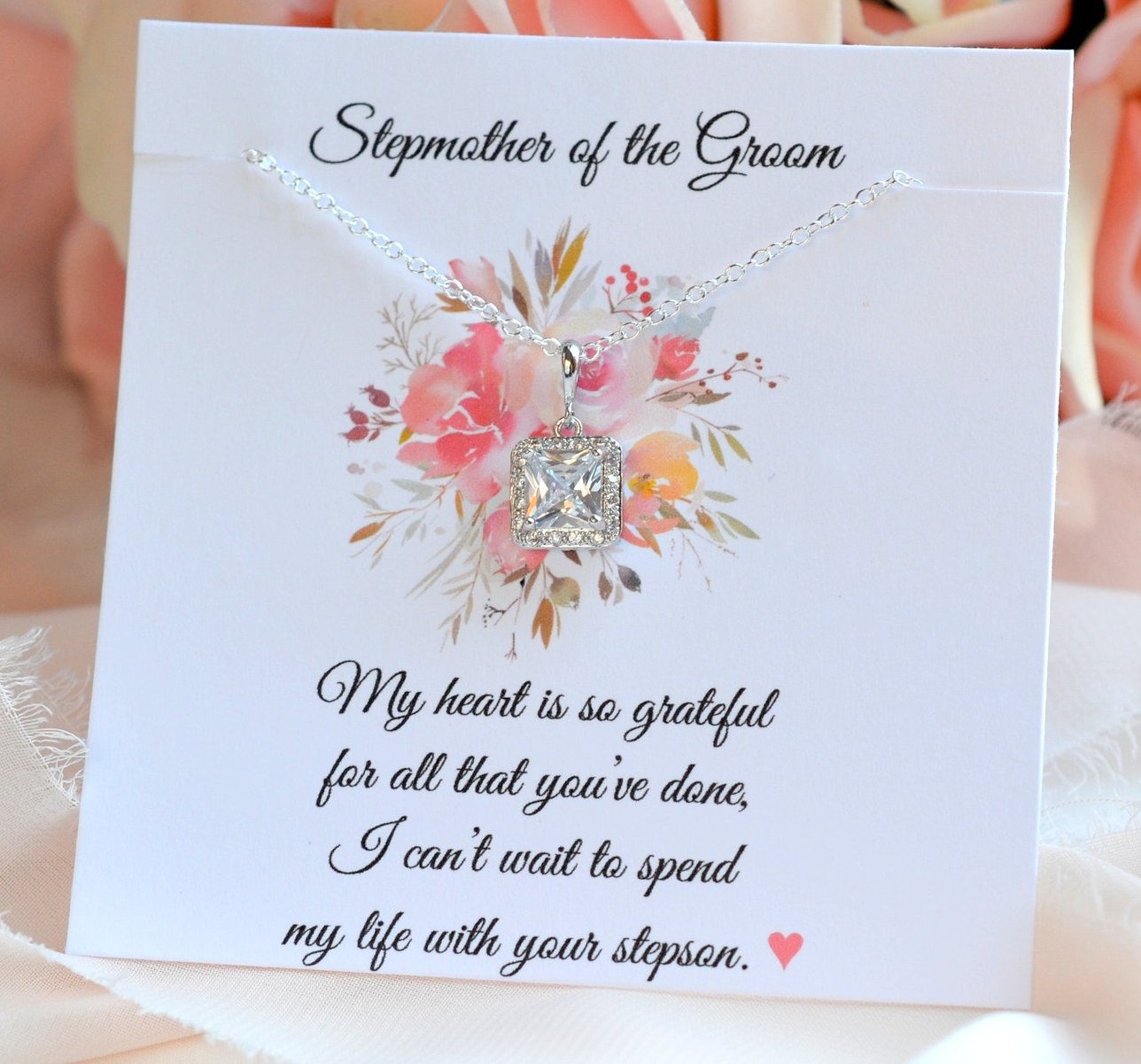 A cubic zirconia princess cut necklace with a silver chain and floral design on a gift card, intended as a stepmother of the bride or groom gift.