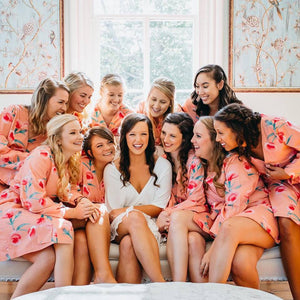 Gorgeous bride surrounded by her bridesmaids after giving them bridesmaid gifts