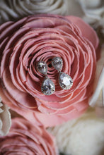 Silver teardrop earrings displayed on brides bouquet on wedding day