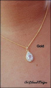 Gold teardrop pendant worn by mother of the bride