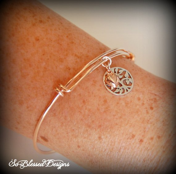 close up of lady wearing rose gold family tree bracelet on wrist