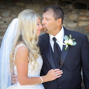 Dad giving daughter a butterfly kiss on the nose on her wedding day