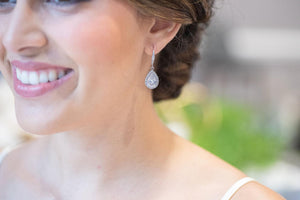 Bride smiling looking at her wedding earrings