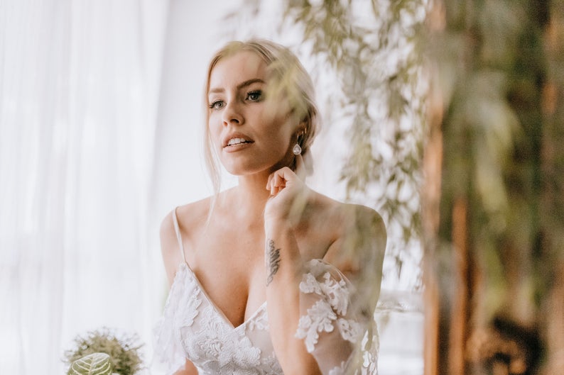 Bride putting on wedding earrings wedding day