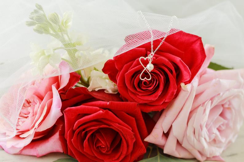 silver and pearl necklace on wedding flowers