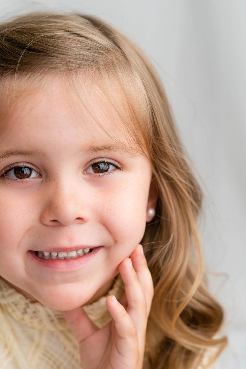 Pearl stud earrings worn on flower girl