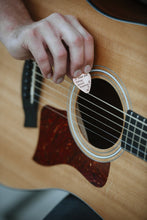 Man playing with personalized copper guitar pick